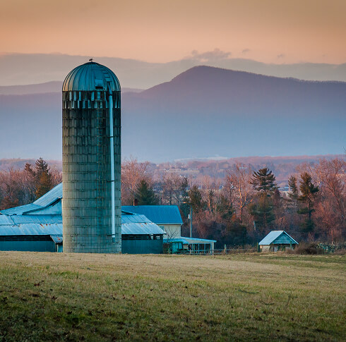 Farm view with mountain range background.