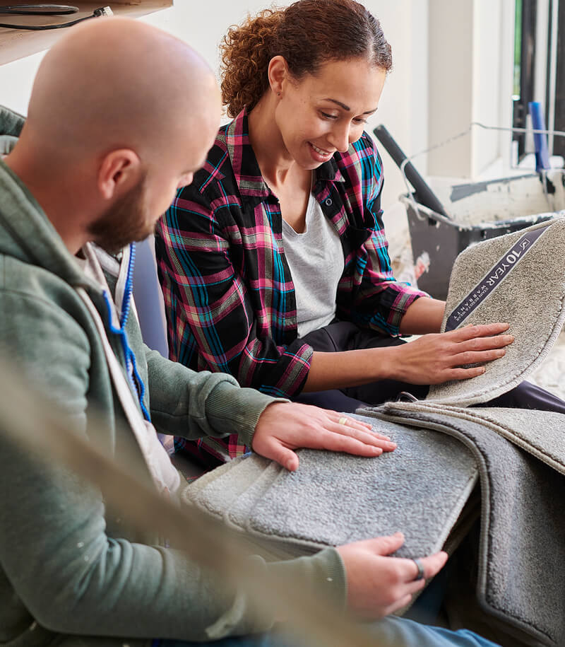 Couple comparing carpet samples.