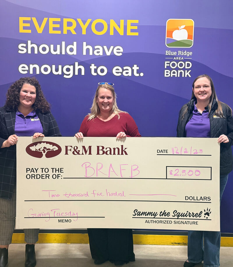Image of people 3 people holding a check. The caption reads Everyone should have enough to eat.