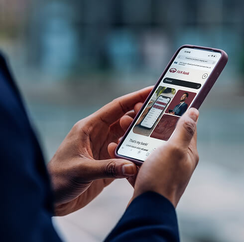 Business person with F&M Bank website on mobile device.