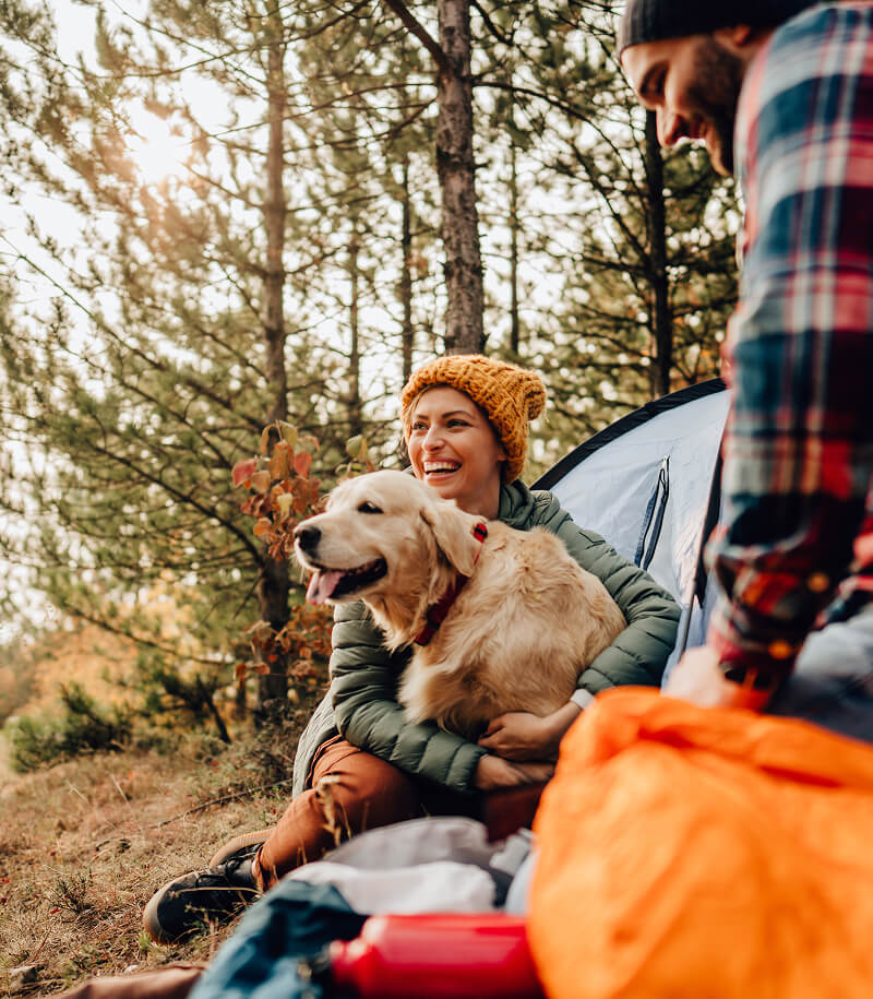 Couple camping with dog.