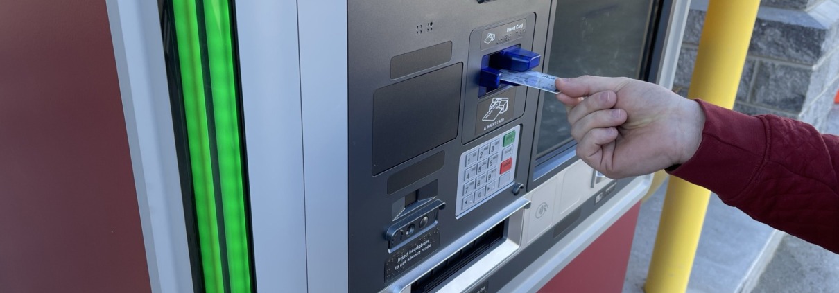Debit card being inserted into ATM machine