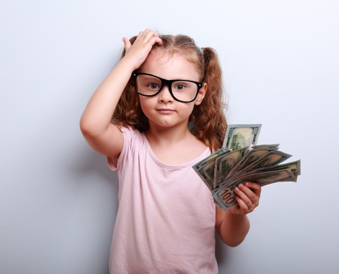 Little girl with money scratching head