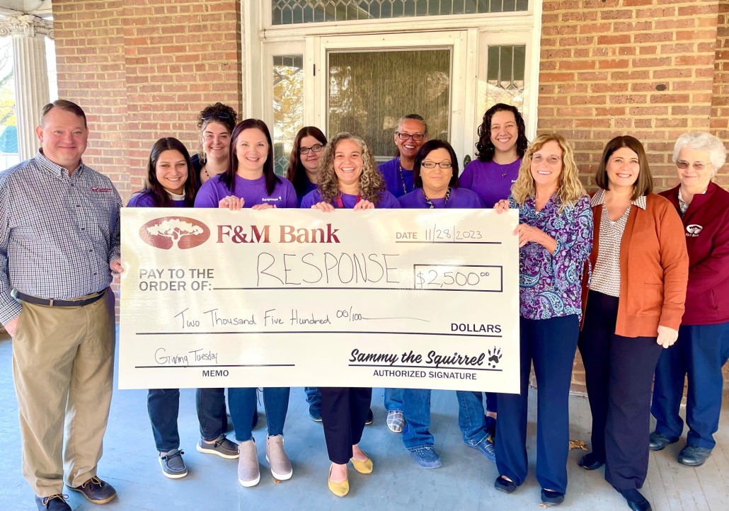 Response board members and F&M Bank employees hold a donation check in celebration of Giving Tuesday