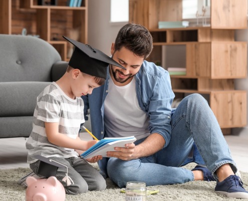 Little boy and father with savings for education at home